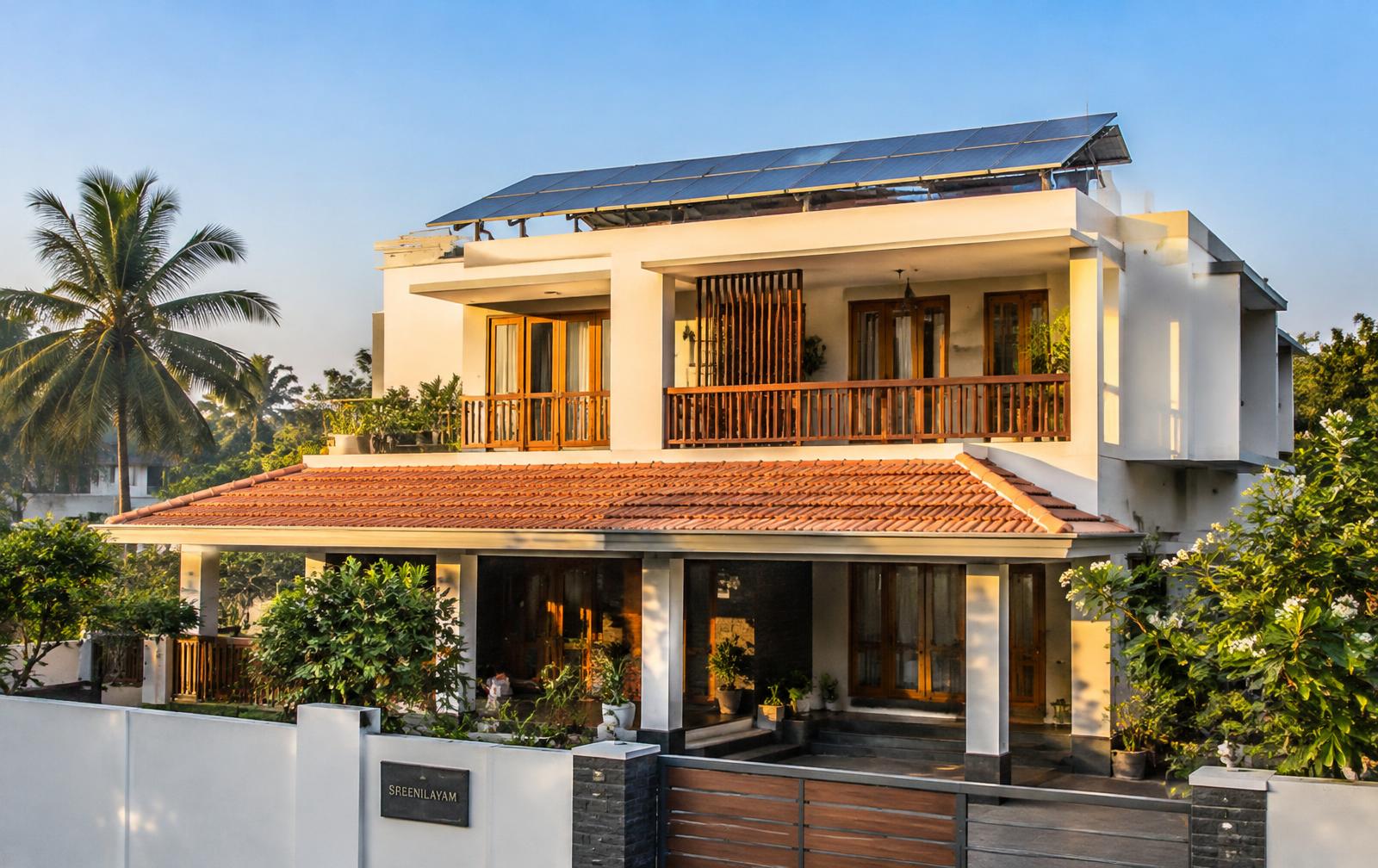Modern Indian home with rooftop solar panels in warm morning sunlight